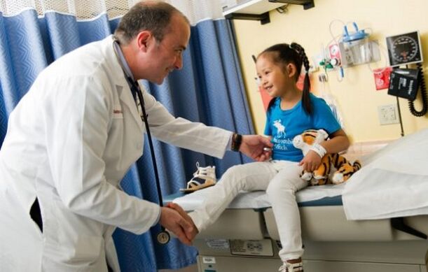 un médico examina a un neno con artrose de cadeira